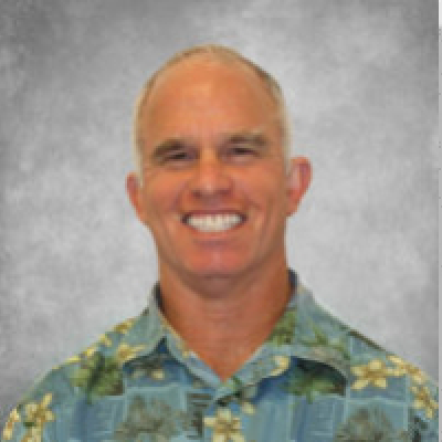 A smiling man in a hawaiian shirt.