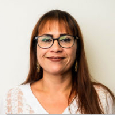 A woman wearing glasses and a white shirt.