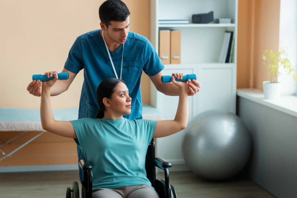 A woman in a wheelchair is doing exercises with dumbbells.