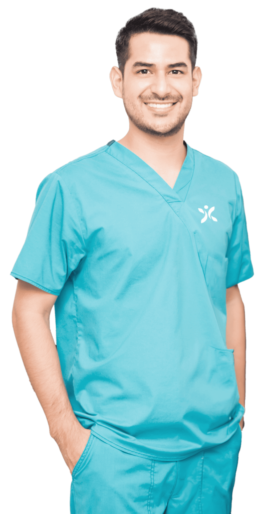 A man in blue scrubs posing for a photo.