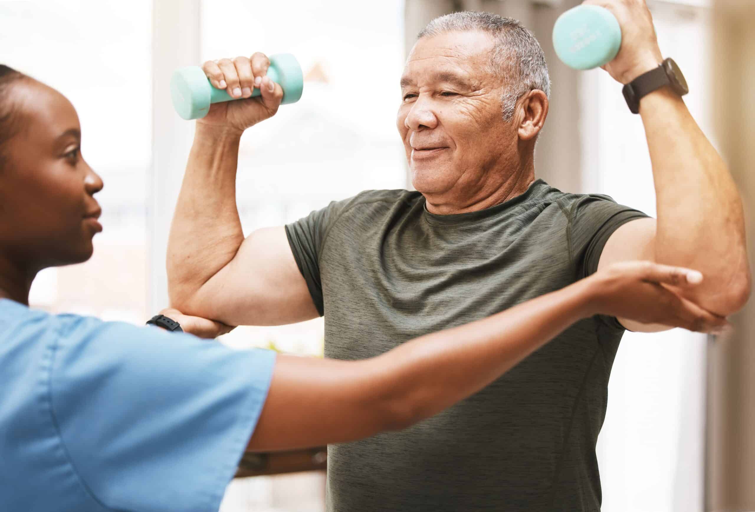 An older man and a nurse working out with dumbbells.