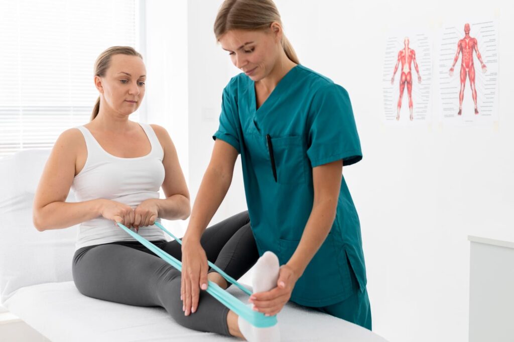 A female physiotherapist is helping a patient stretch her leg.