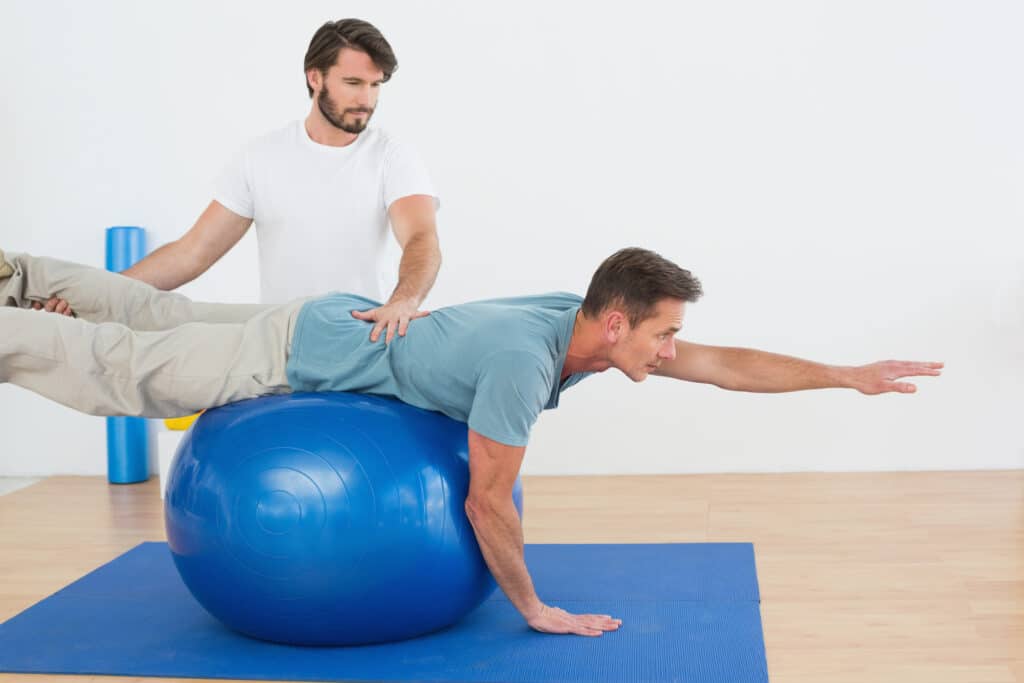 A man is doing exercises on an exercise ball.