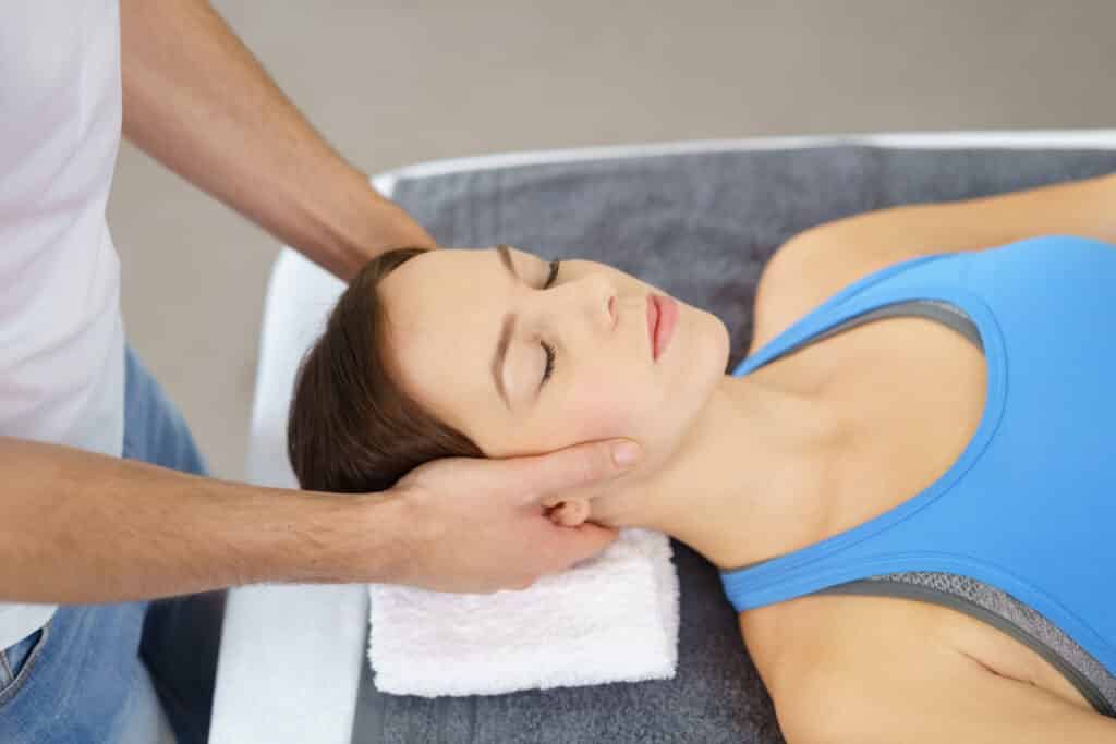 A woman getting a neck massage at a physiotherapy clinic.